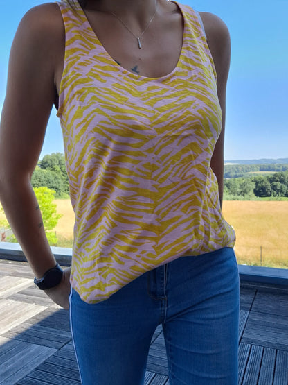 Débardeur bariolé jaune upcyclé en coton/lin à motif zébré rose, porté avec un jean bleu