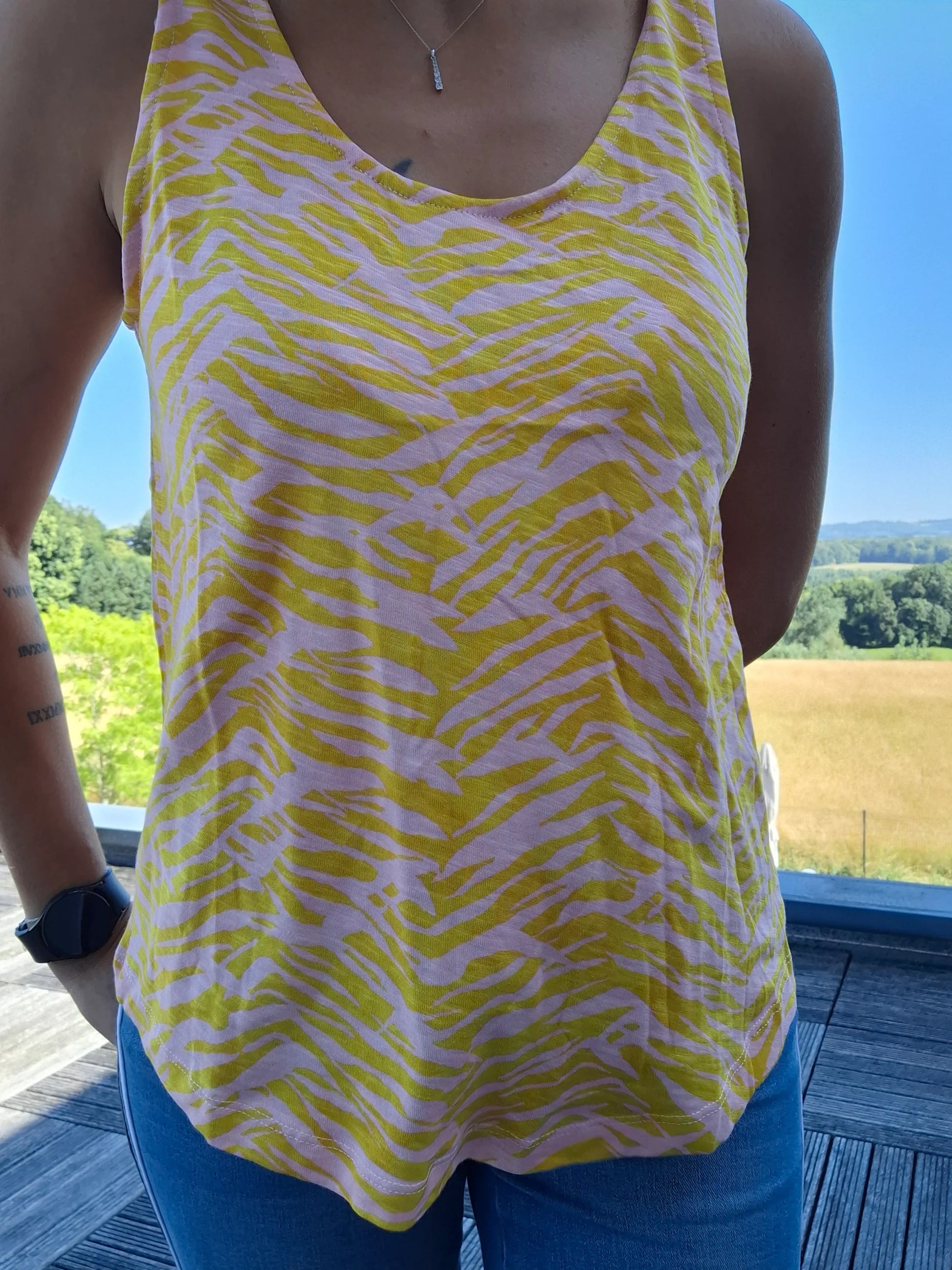 Débardeur bariolé jaune upcyclé en coton/lin à motif zébré porté par une femme en extérieur