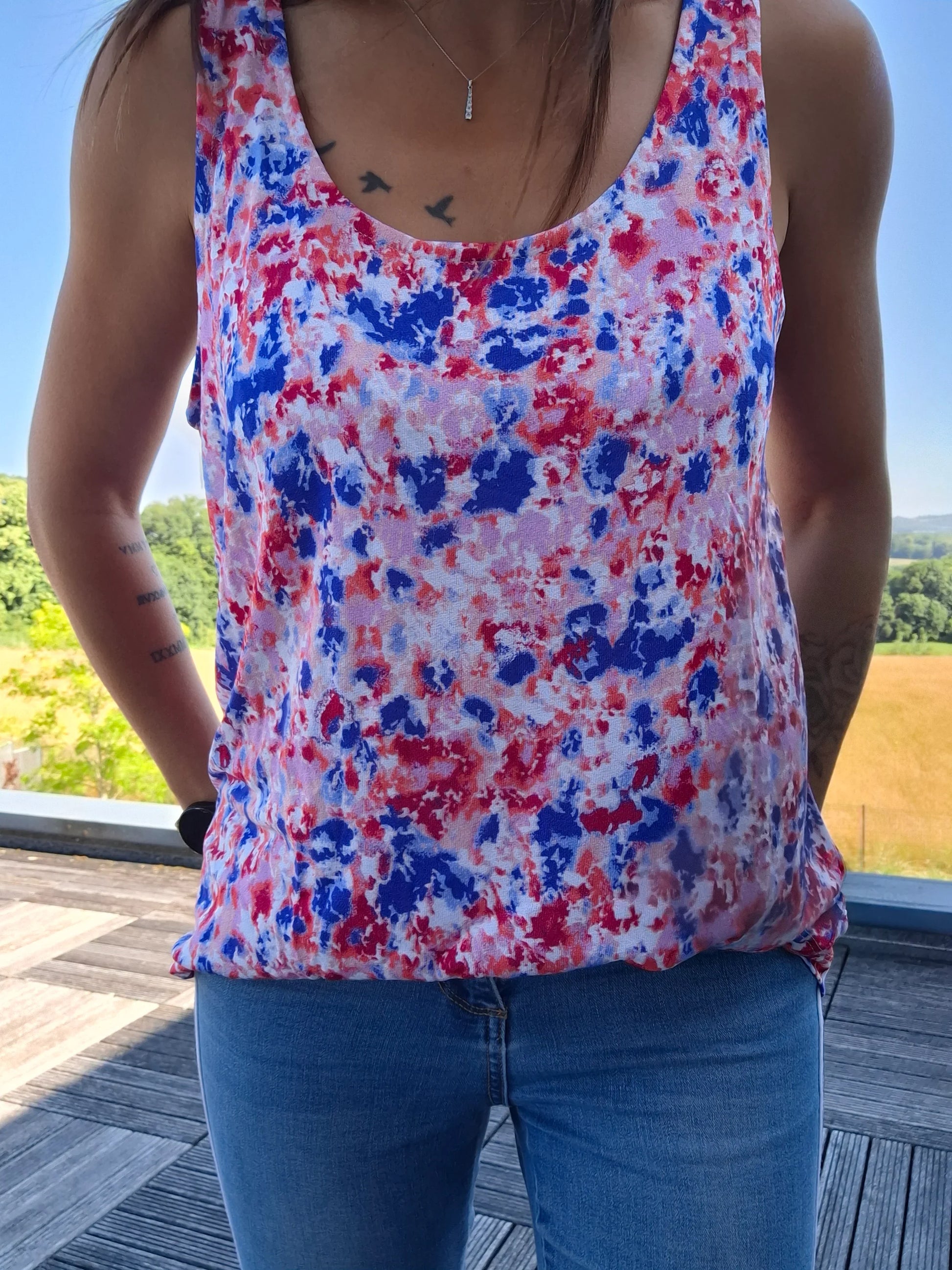 Débardeur fleuri bleu et rouge upcyclé en coton/lin porté avec un jean, imprimé floral coloré, coupe ample