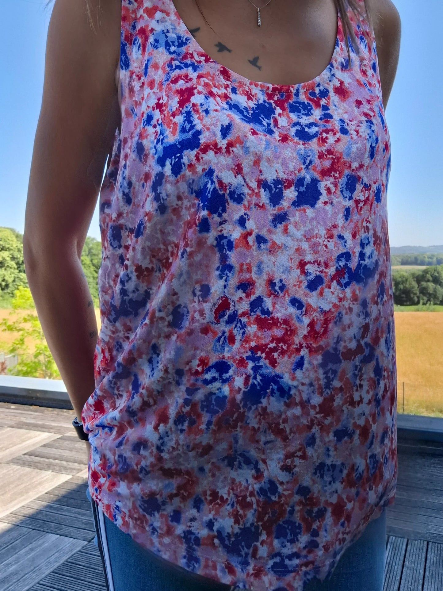 Débardeur fleuri bleu et rouge upcyclé en coton/lin porté par une femme, imprimé floral coloré, style ample et léger