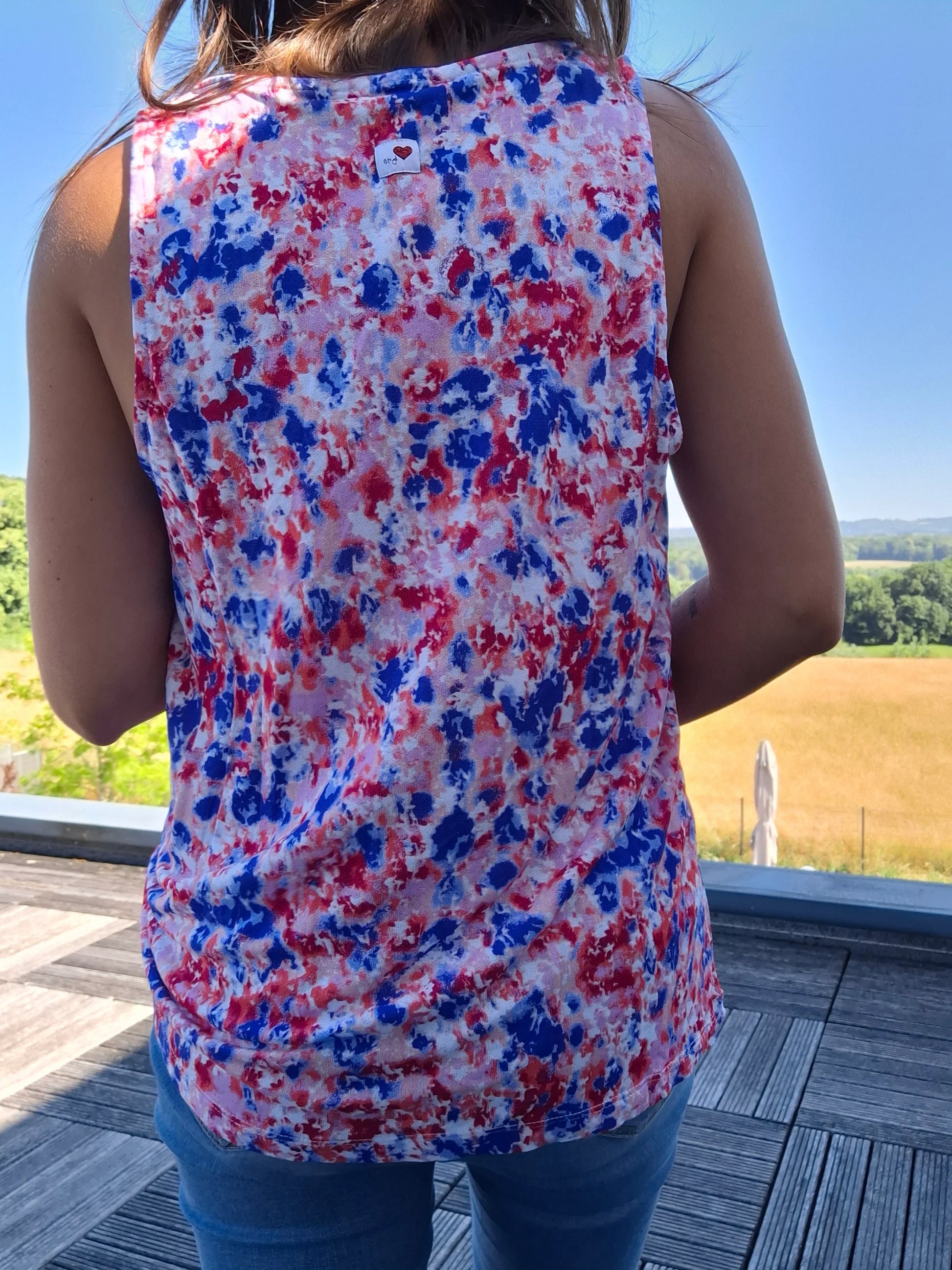 Débardeur fleuri bleu et rouge upcyclé en coton/lin porté de dos par une femme, motif floral coloré