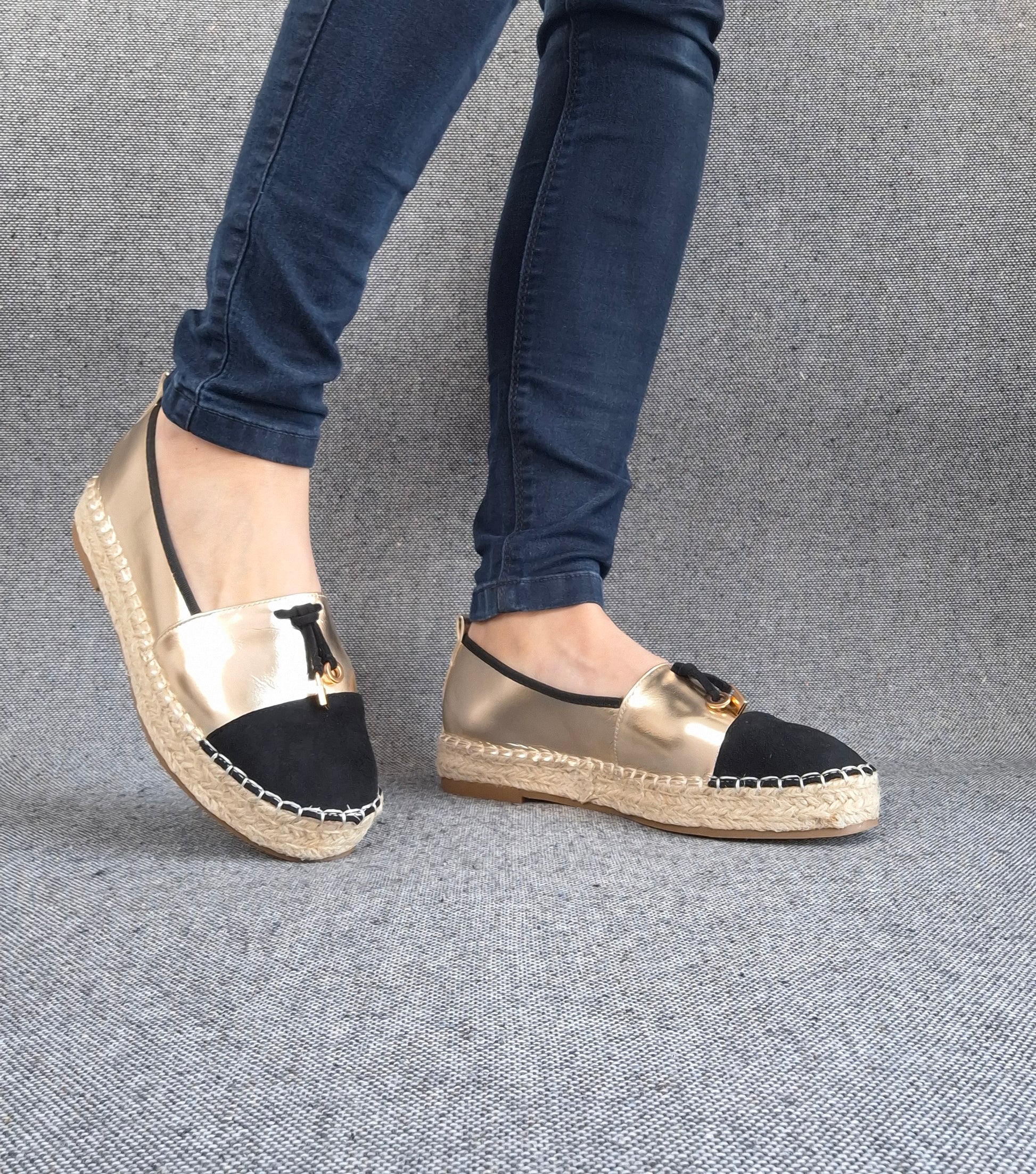 Espadrilles plates bicolore or et noir à bout noir, semelle tressée, portées avec un jean bleu