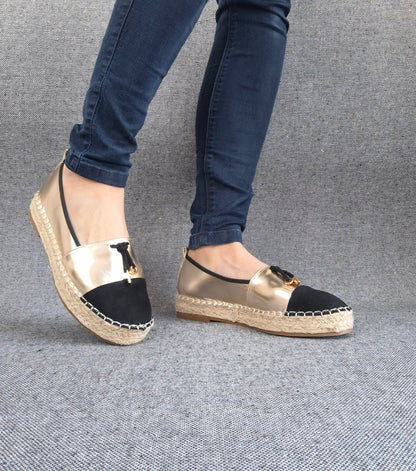 Espadrilles plates bicolore or et noir à bout noir, semelle tressée, portées avec un jean bleu