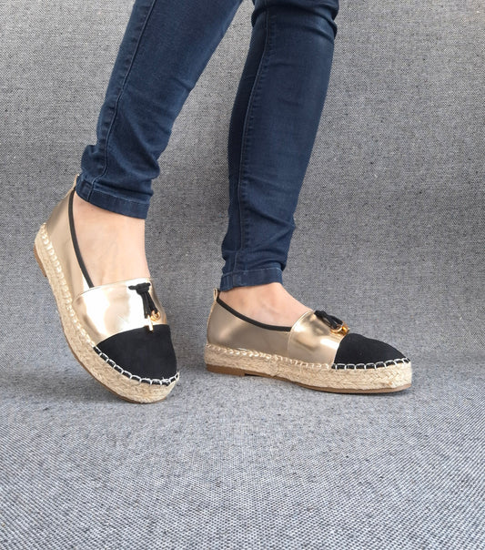 Espadrilles plates bicolore or et noir à bout noir, semelle tressée, portées avec un jean bleu
