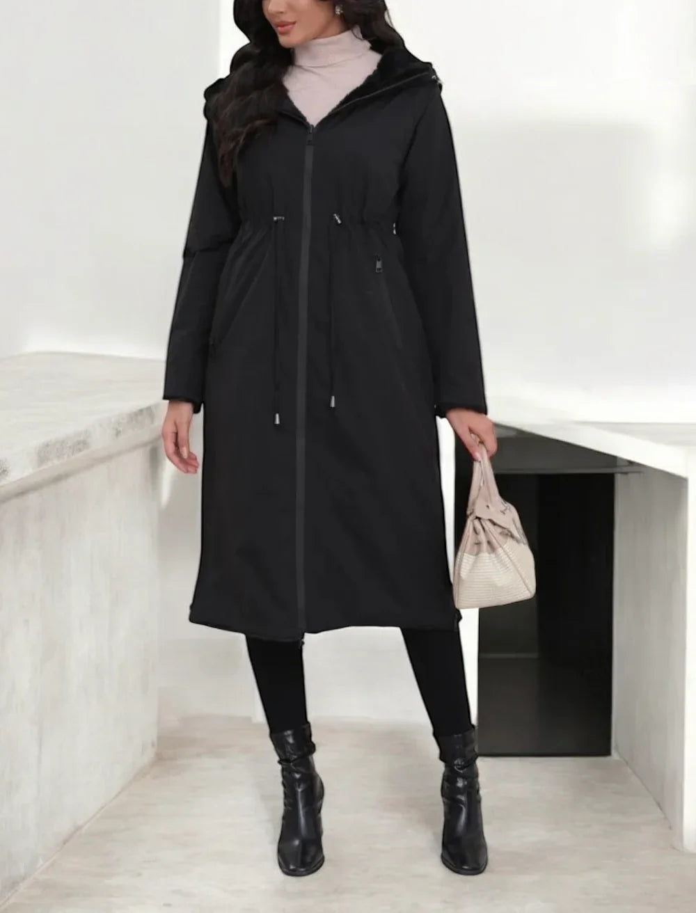 Manteau long réversible noir en fausse fourrure avec capuche et coupe ajustée.