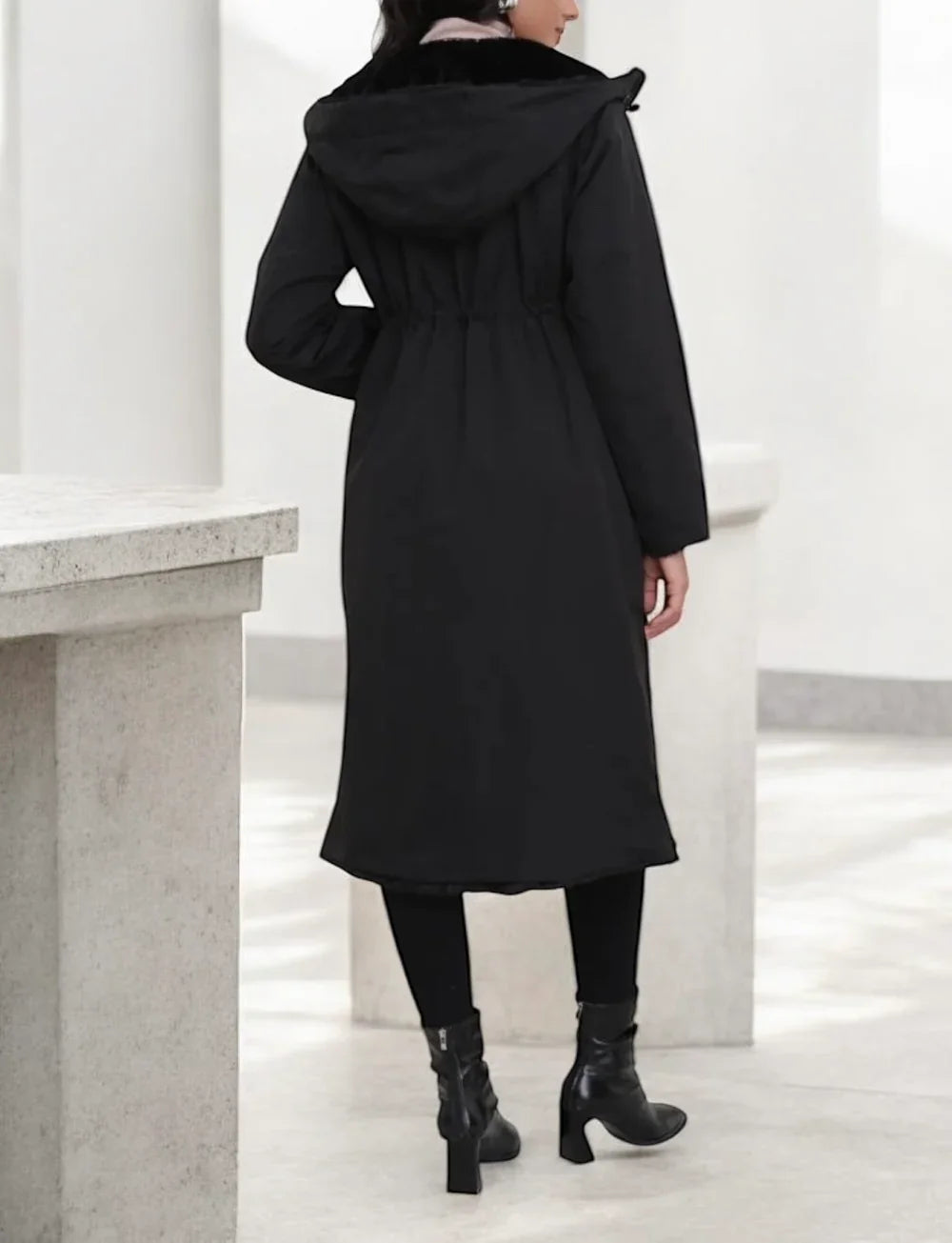 Manteau long réversible noir en fausse fourrure avec capuche et coupe ajustée,  vue de dos
