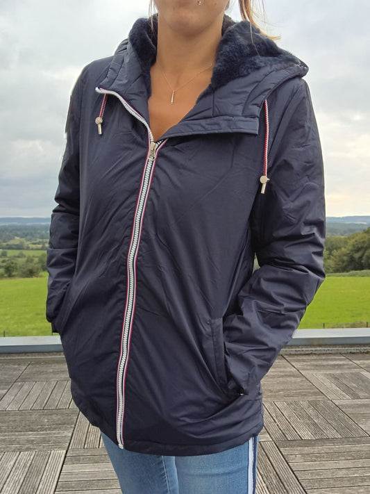 Woman wearing a navy Laura Jo raincoat from Le Petit Placard, outdoor setting.