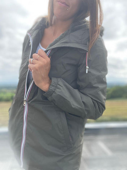 Woman wearing a green Laura Jo raincoat outdoors, Le Petit Placard fashion.
