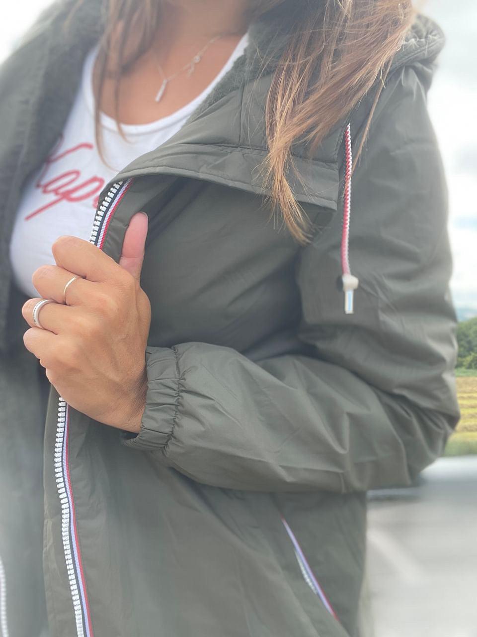 Woman wearing a Laura Jo waterproof jacket in khaki, outdoor scene, Le Petit Placard