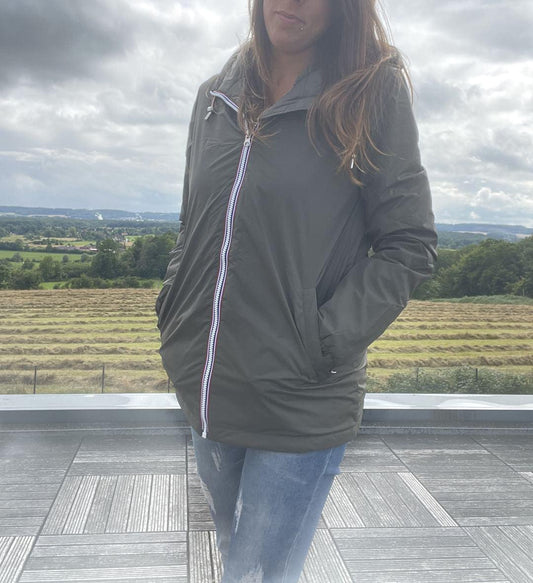Woman wearing Laura Jo green raincoat and jeans outdoors, Le Petit Placard collection