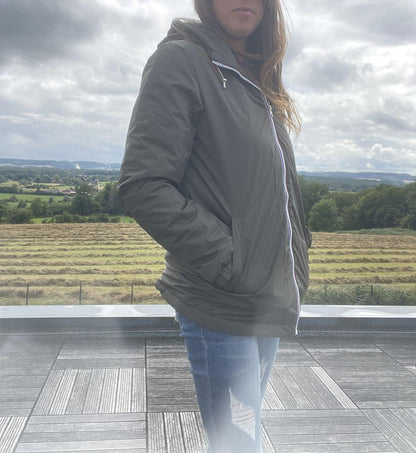 Woman wearing Laura Jo green raincoat and ripped jeans outdoors, Le Petit Placard collection