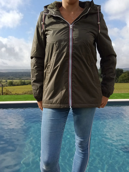 Woman wearing Laura Jo khaki rain jacket by a pool, outdoor fashion at Le Petit Placard