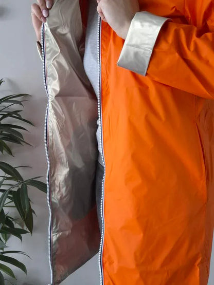 Person wearing orange Laura Jo raincoat, showing silver lining, Le Petit Placard fashion