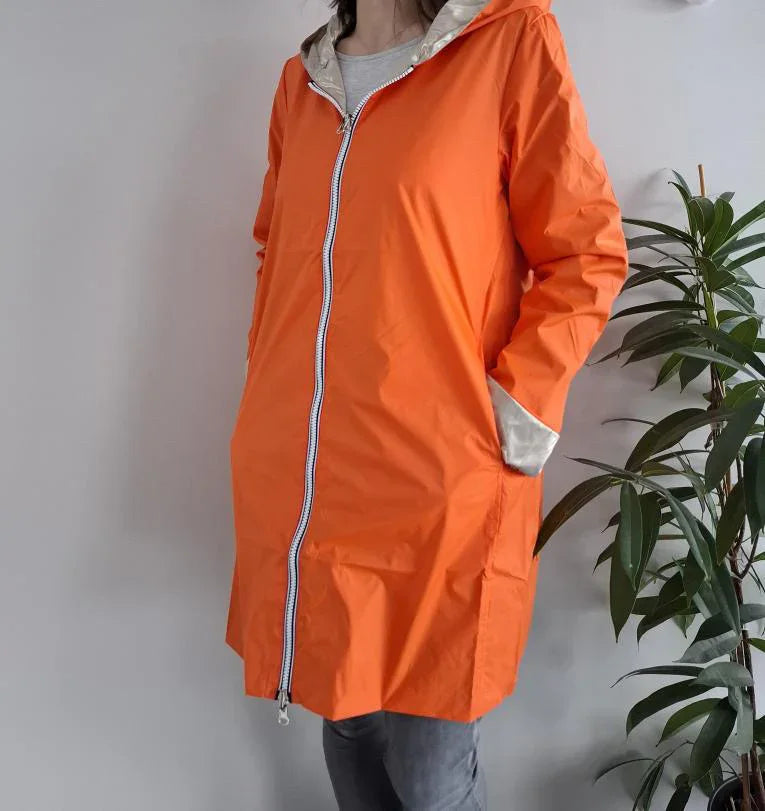 Woman wearing bright orange Laura Jo raincoat with hood, Le Petit Placard fashion