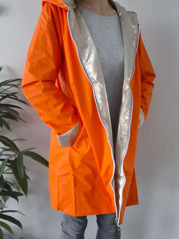 Woman wearing bright orange Laura Jo raincoat with metallic lining, Le Petit Placard