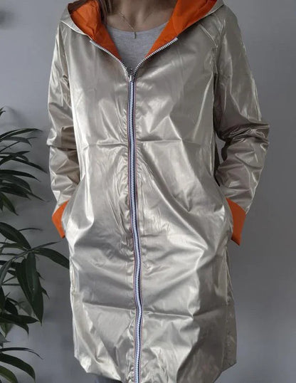 Metallic beige Laura Jo raincoat with orange hood and cuffs, displayed on model