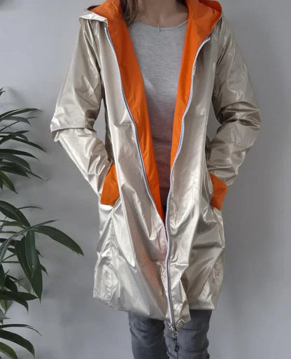 Woman wearing shiny beige Laura Jo raincoat with orange lining, trendy outerwear from Le Petit Placard