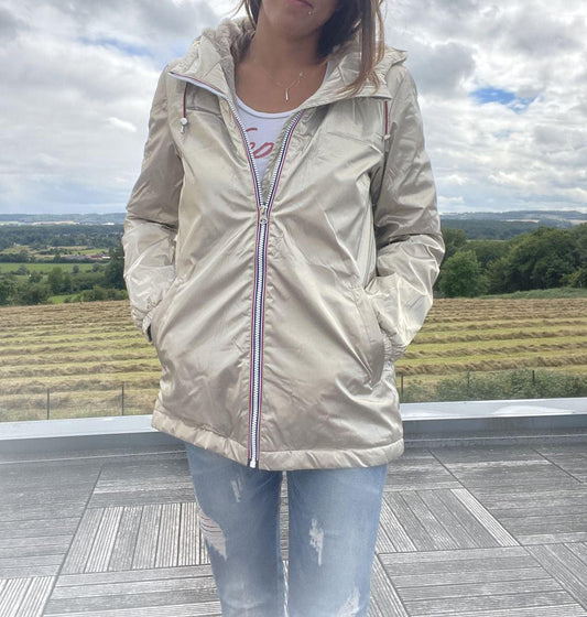 Woman wearing a metallic Laura Jo raincoat and ripped jeans outdoors at Le Petit Placard
