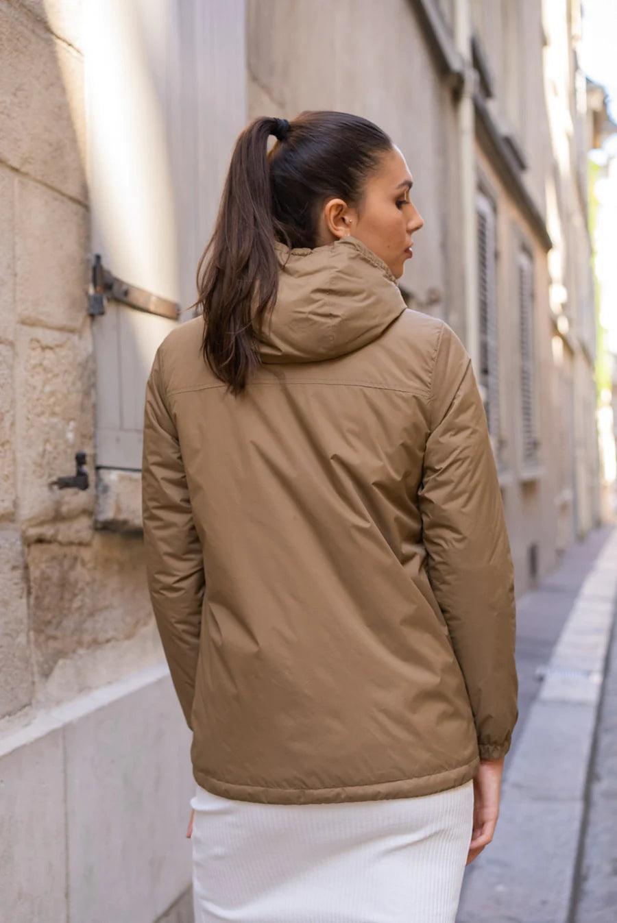 Woman wearing a camel Laura Jo raincoat from Le Petit Placard in a city street