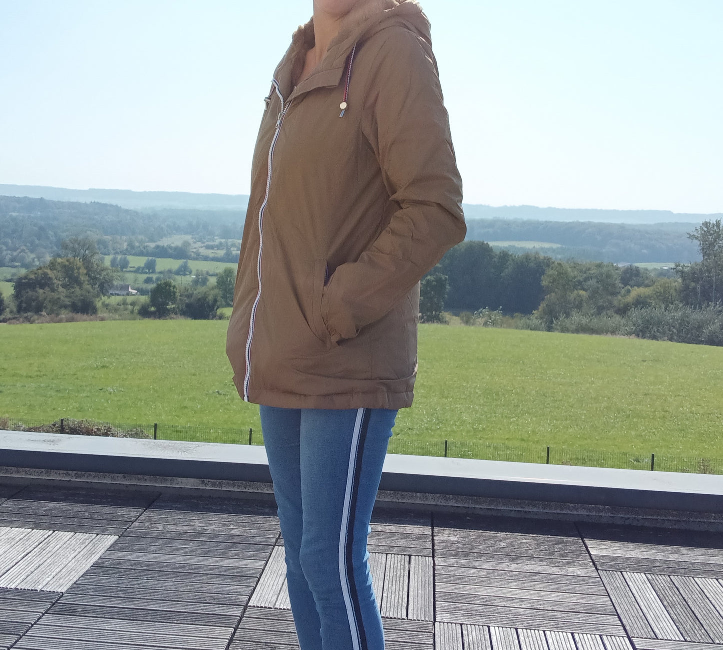 Woman wearing a camel Laura Jo raincoat and jeans outdoors, Le Petit Placard collection