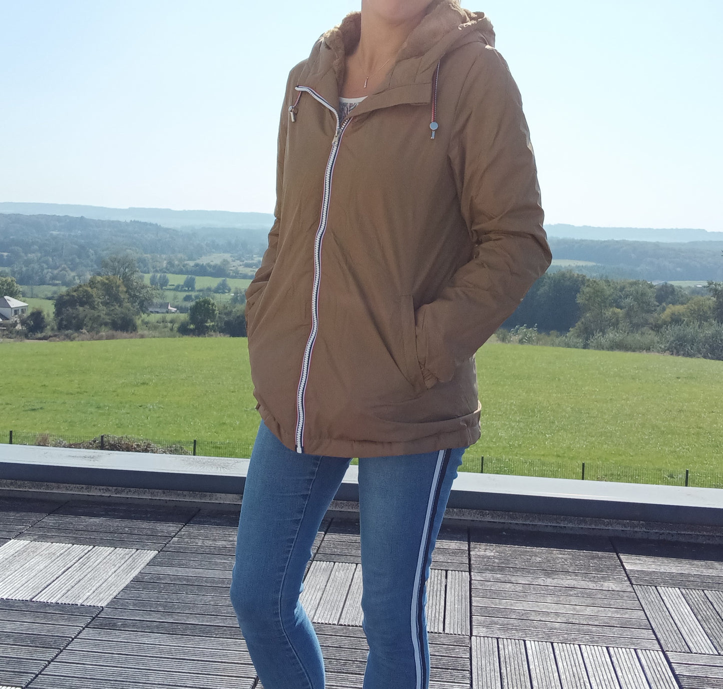 Woman wearing camel Laura Jo raincoat and jeans outdoors, Le Petit Placard fashion