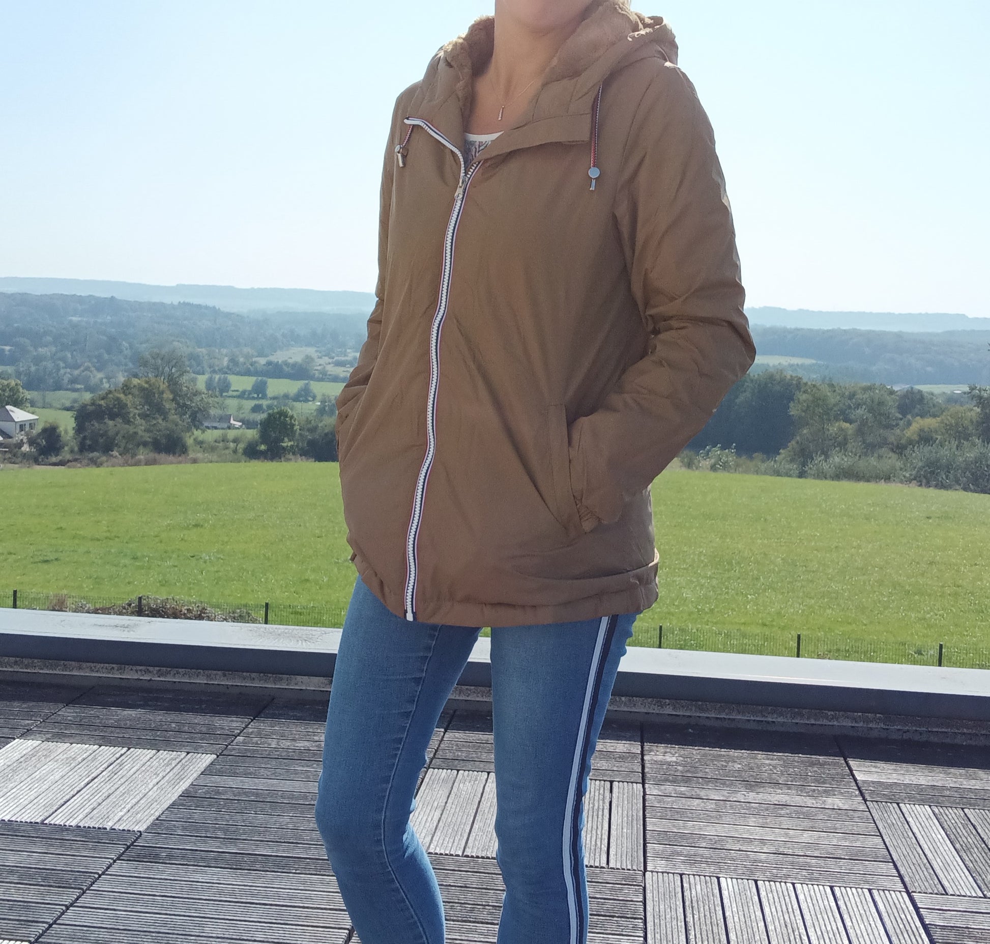 Woman wearing camel Laura Jo raincoat and jeans outdoors, Le Petit Placard fashion