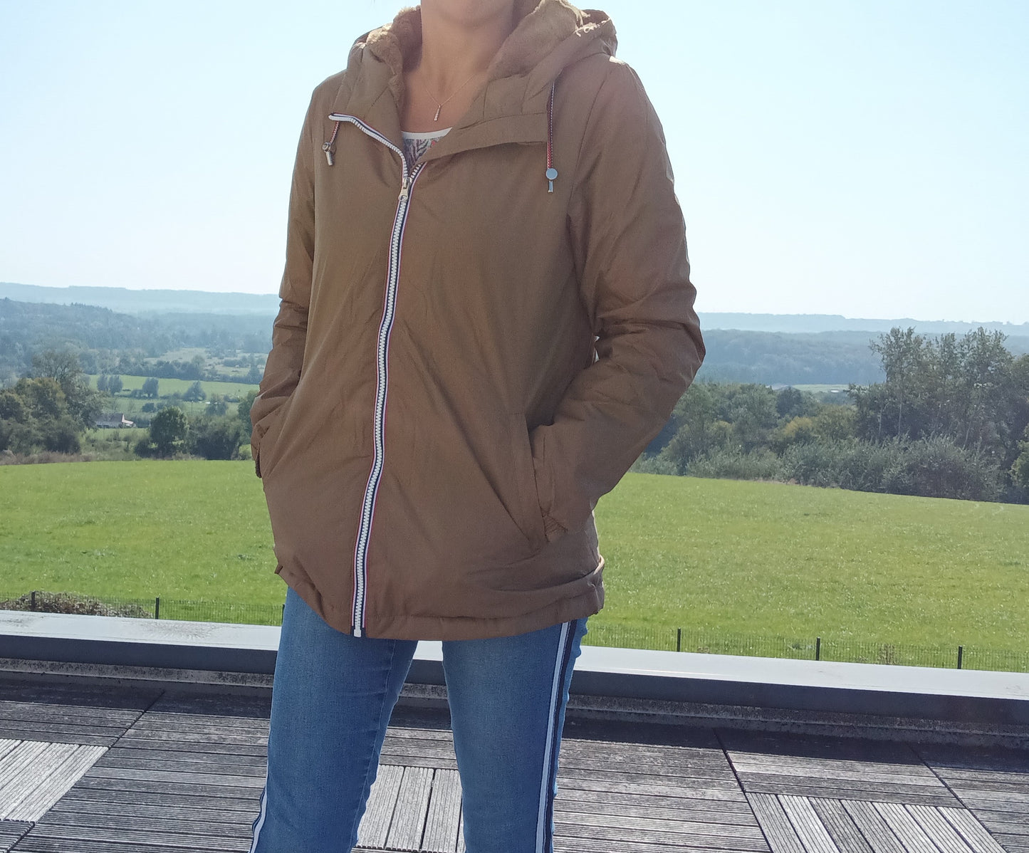 Woman in camel Laura Jo raincoat and jeans outdoors, Le Petit Placard fashion