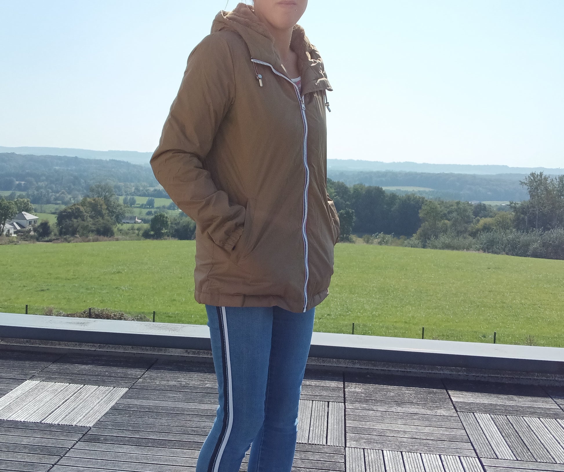 Woman modeling camel Laura Jo rain jacket outdoors, casual jeans, Le Petit Placard fashion