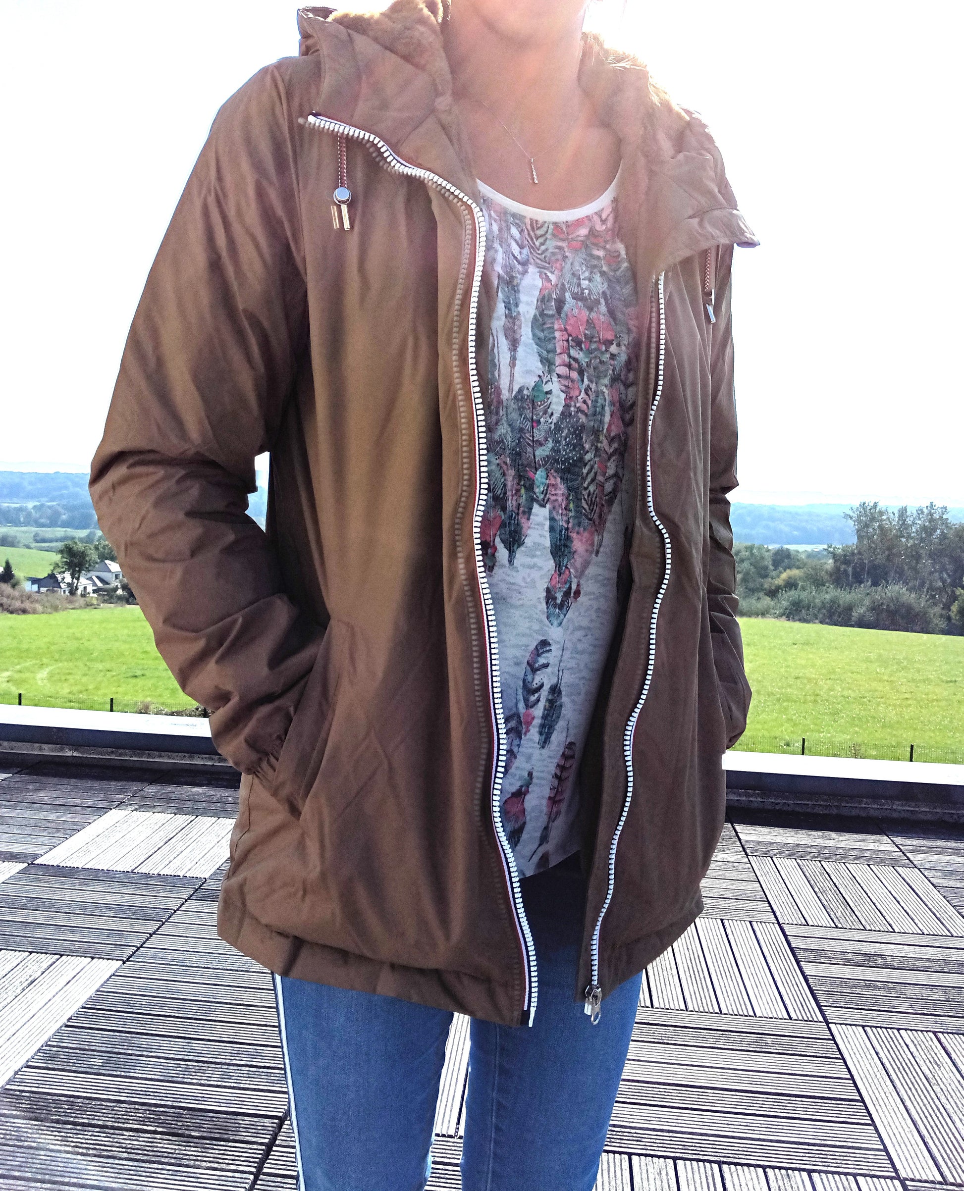 Woman wearing brown Laura Jo raincoat with hood and jeans outdoors, Le Petit Placard fashion