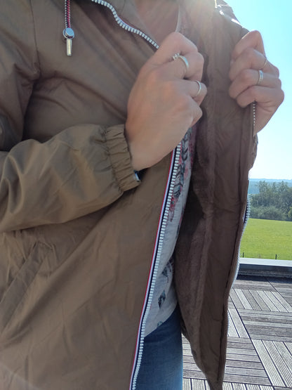 Person opening camel Laura Jo raincoat with soft lining, outdoor sunlight, Le Petit Placard