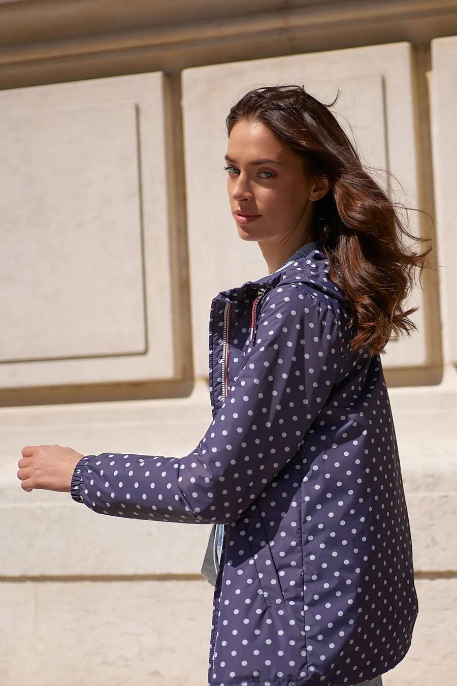 Woman wearing a navy blue Laura Jo polka dot raincoat, Le Petit Placard collection
