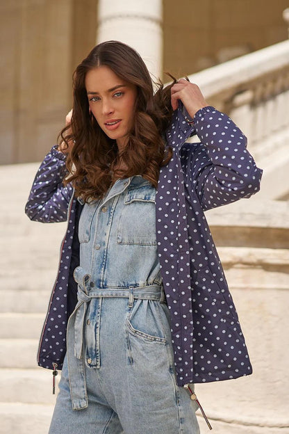 Woman in a blue polka dot Laura Jo raincoat over denim jumpsuit, Le Petit Placard collection