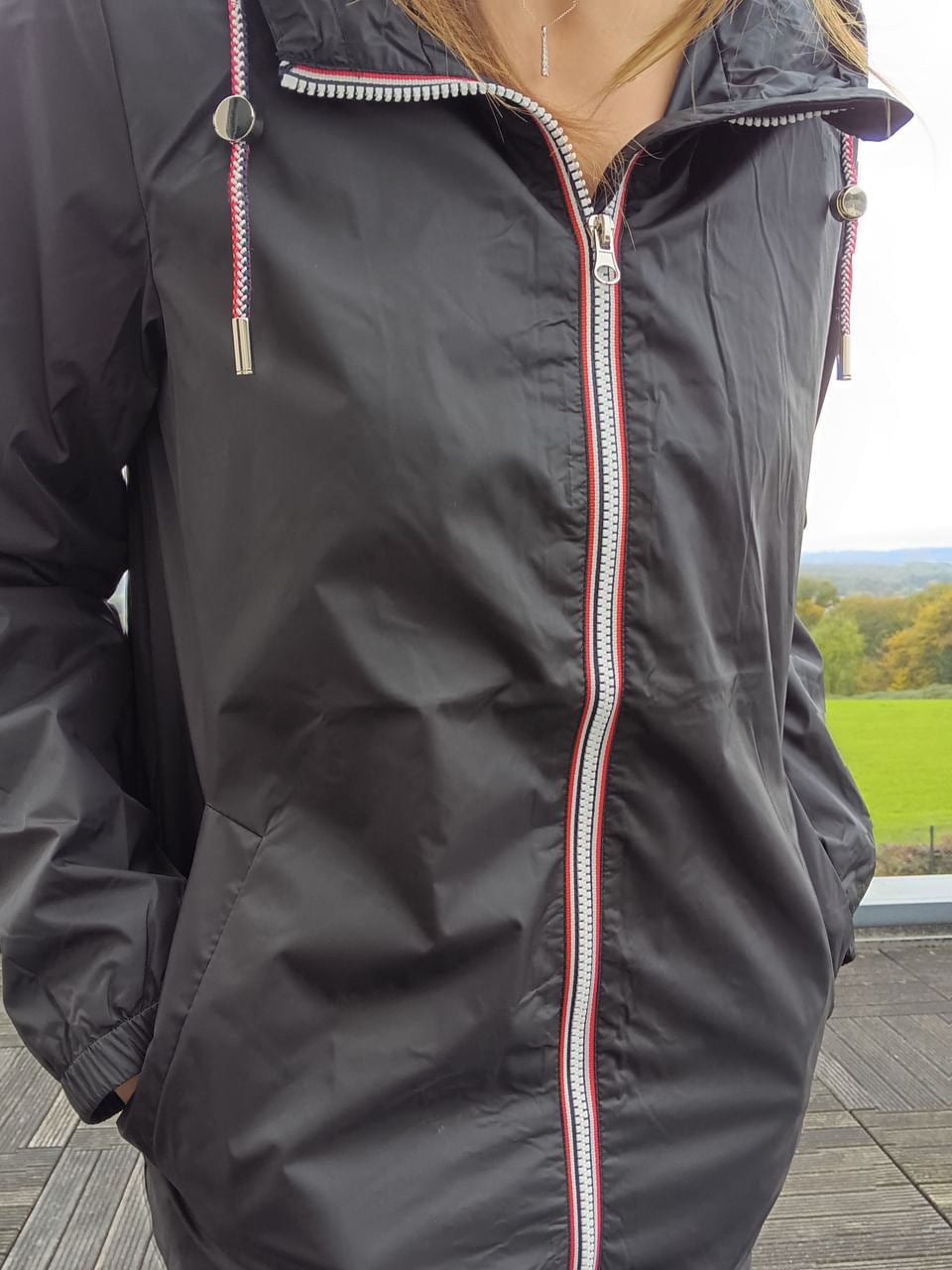 Woman wearing Laura Jo black rain jacket with striped zipper, Le Petit Placard outdoor style