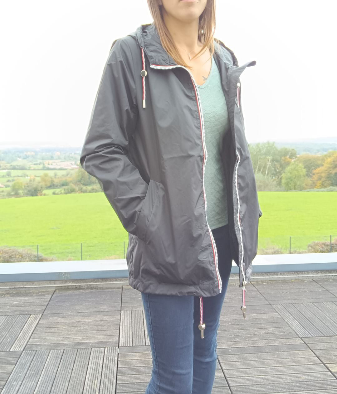 Woman wearing a black Laura Jo mid-length raincoat outdoors, Le Petit Placard fashion