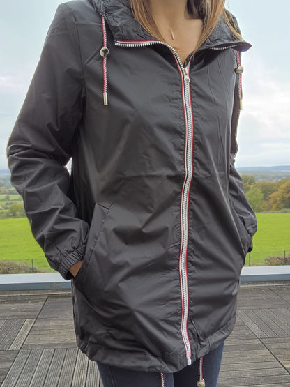 Black mid-length Laura Jo raincoat with zip, outdoor setting, Le Petit Placard collection