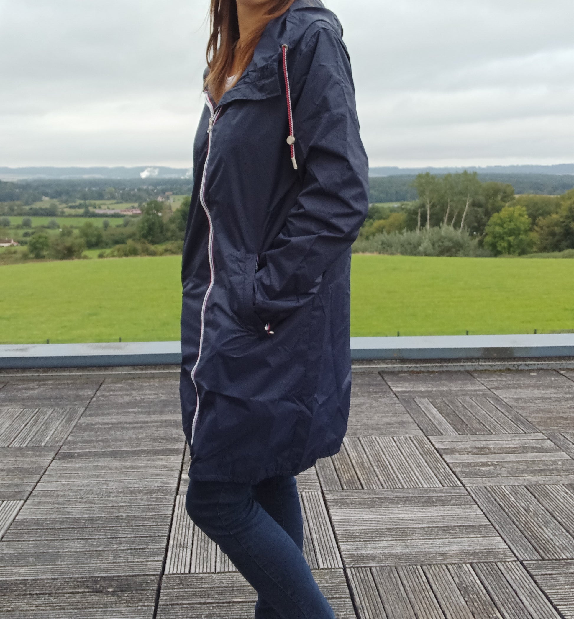 Femme portant une parka manteau bleu marine imperméable longue à capuche Laura Jo, vue de profil en extérieur