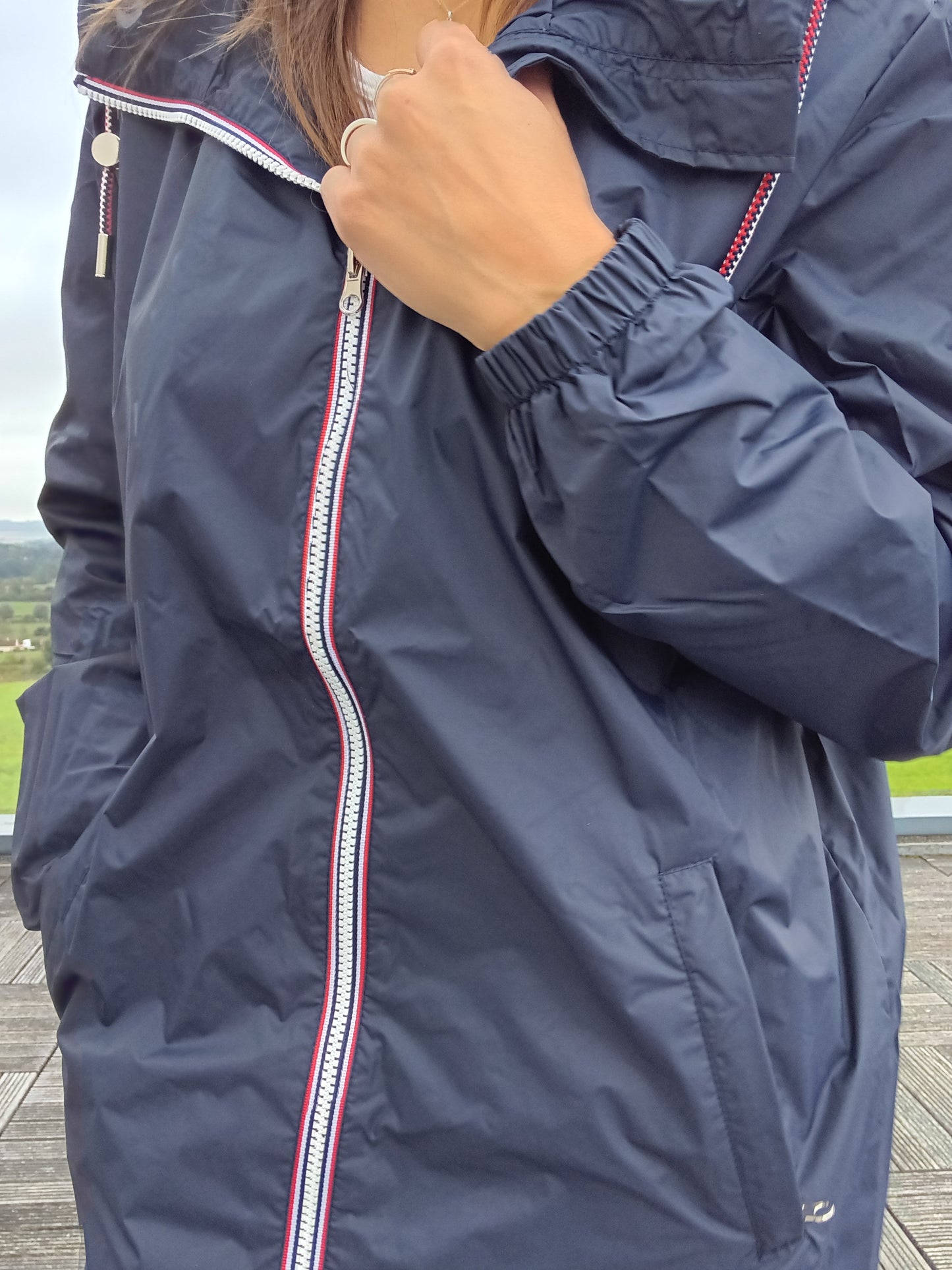 Détail zip et poche de la parka manteau bleu marine imperméable longue Laura Jo, bordures rouge et blanc