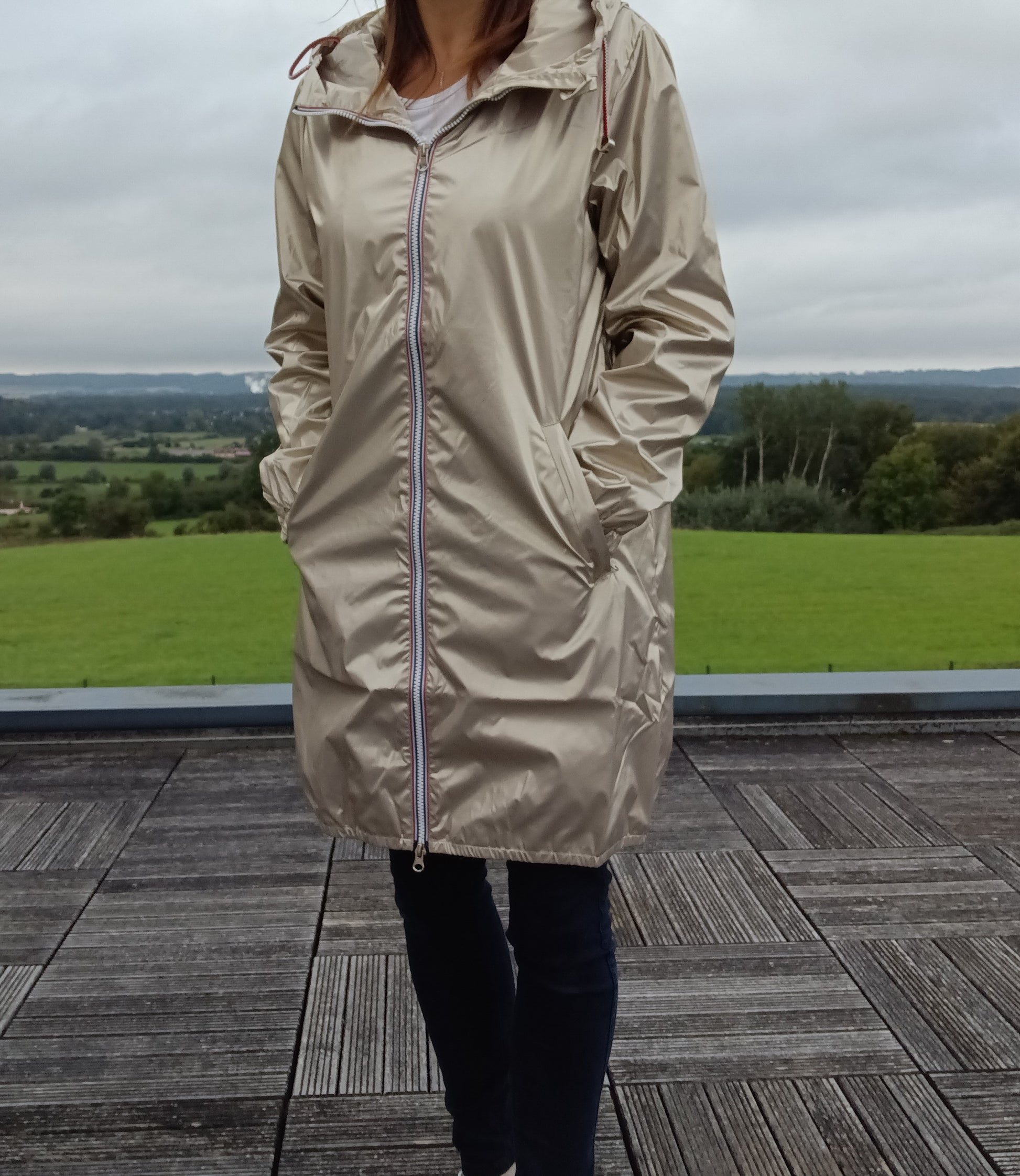 Femme portant le parka manteau doré imperméable long Laura Jo à capuche et fermeture éclair, coupe longue fine doublure