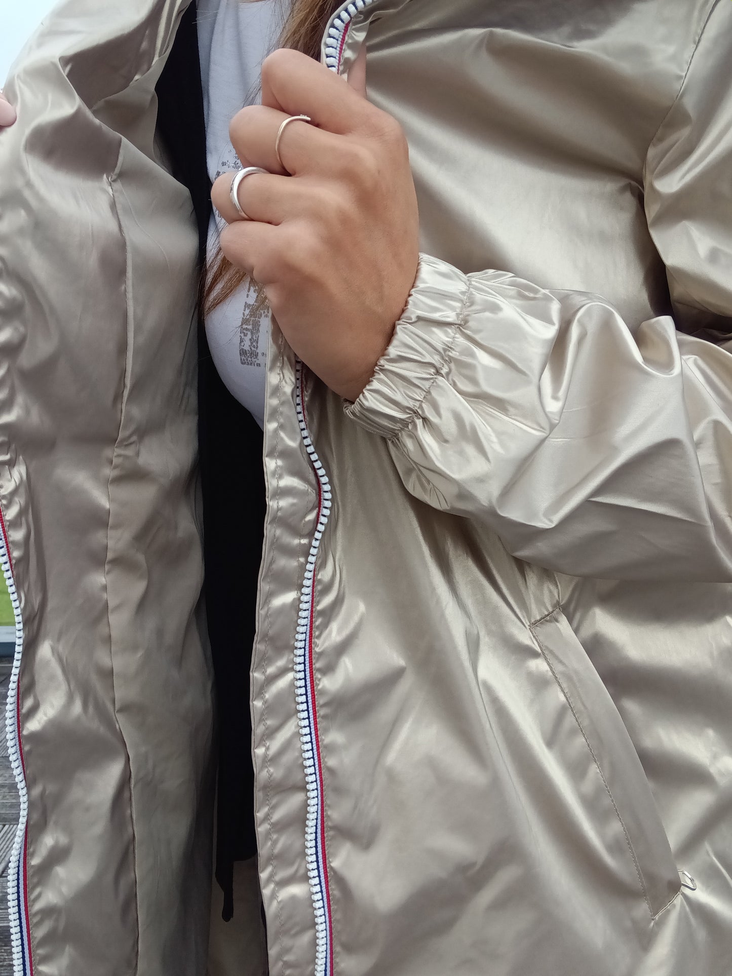 Détail zip et manche élastiquée du parka manteau doré imperméable Laura Jo, tissu léger brillant doré