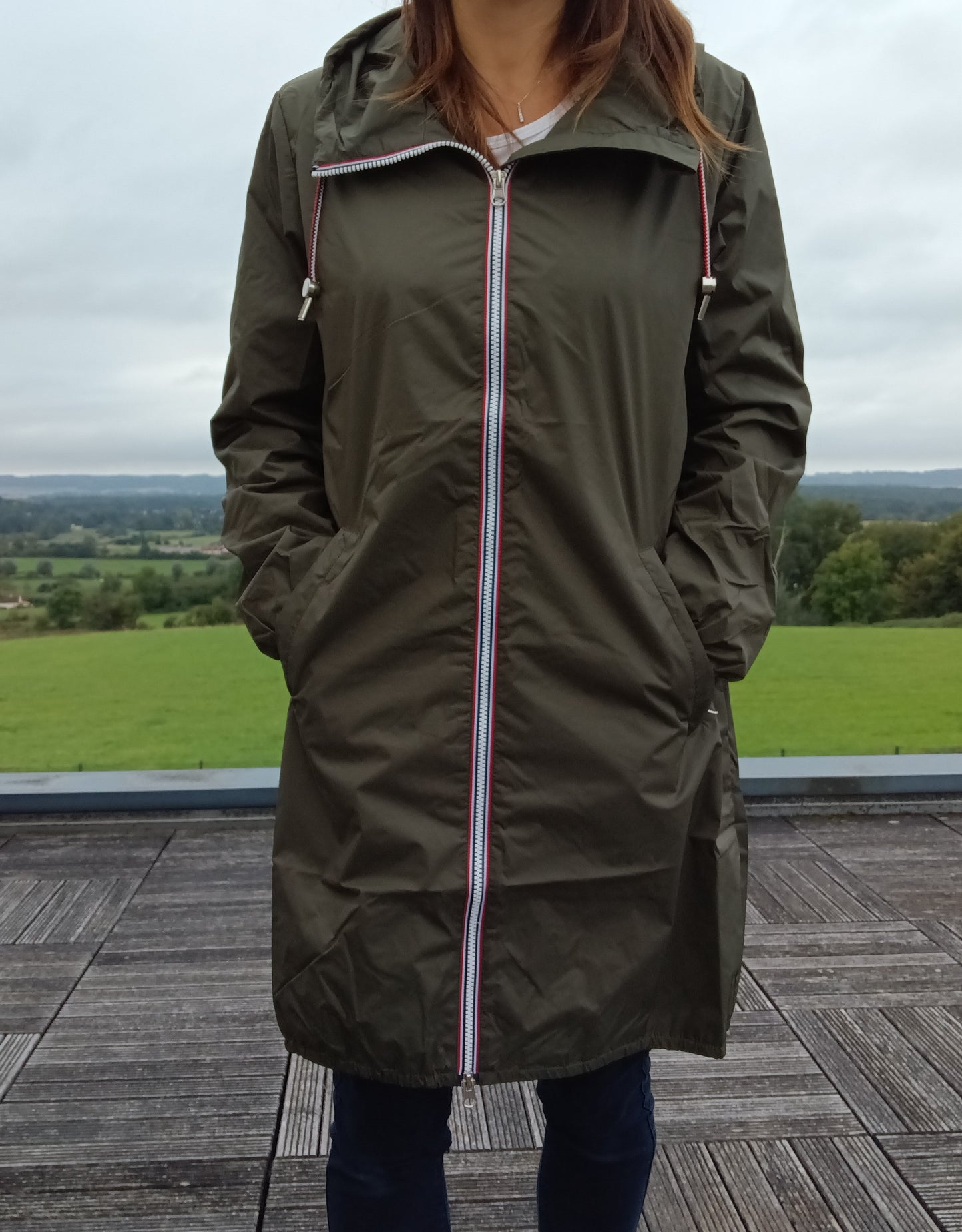 Kaki Laura Jo long waterproof parka with hood, worn outdoors on a terrace, Le Petit Placard