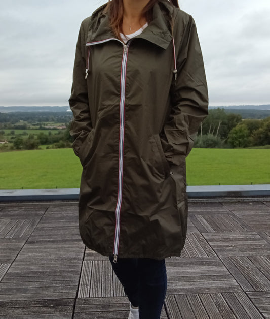 Woman wearing Laura Jo khaki raincoat with zipper, standing on terrace, outdoor view