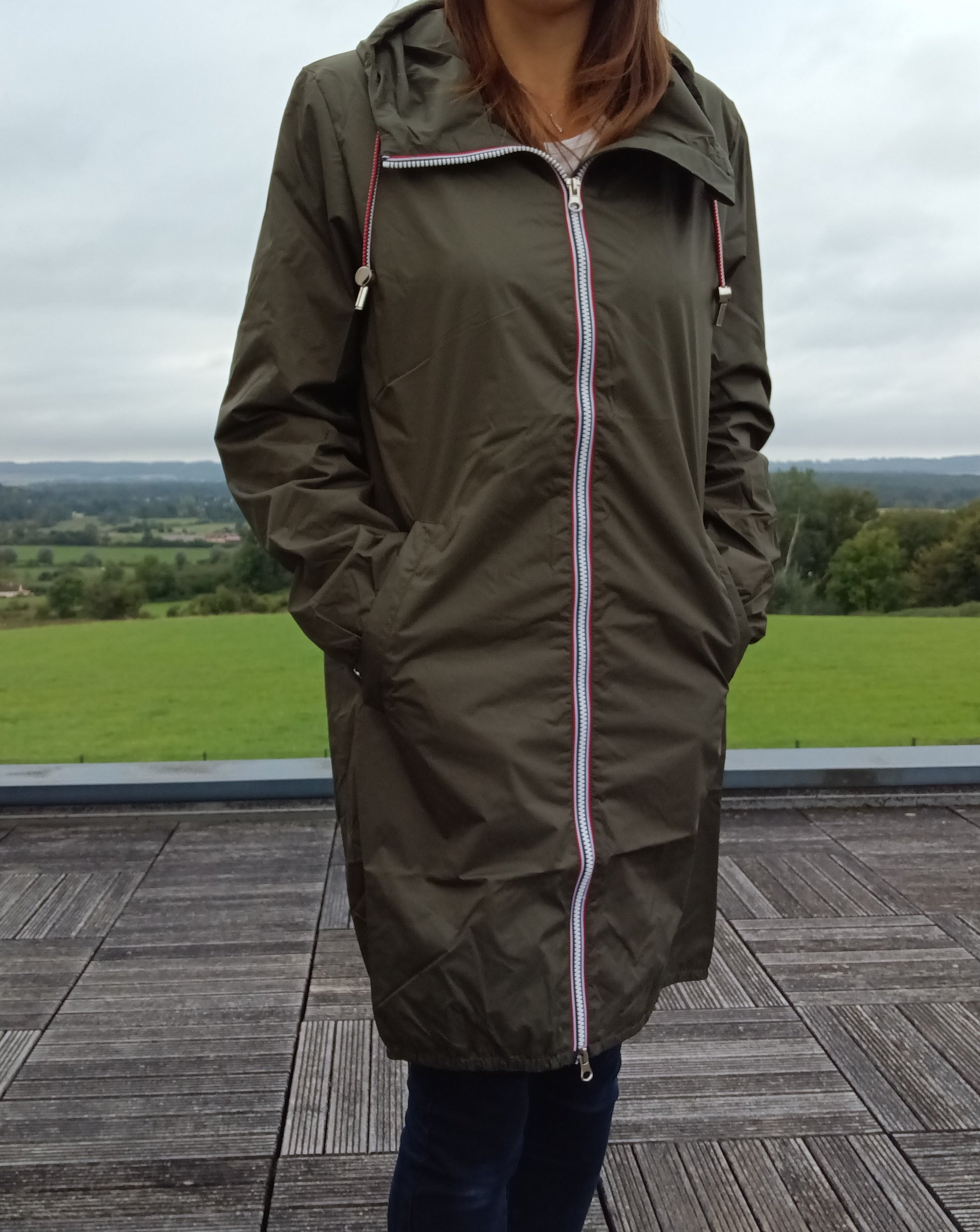 Woman wearing khaki Laura Jo raincoat outdoors, Le Petit Placard trendy waterproof jacket