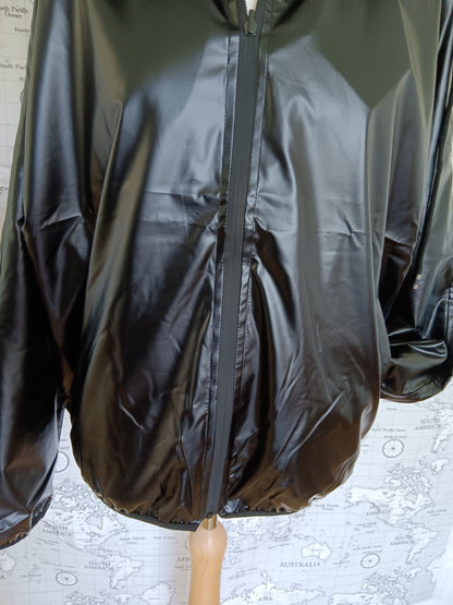 Black reversible raincoat with matte finish, displayed on a mannequin at Le Petit Placard
