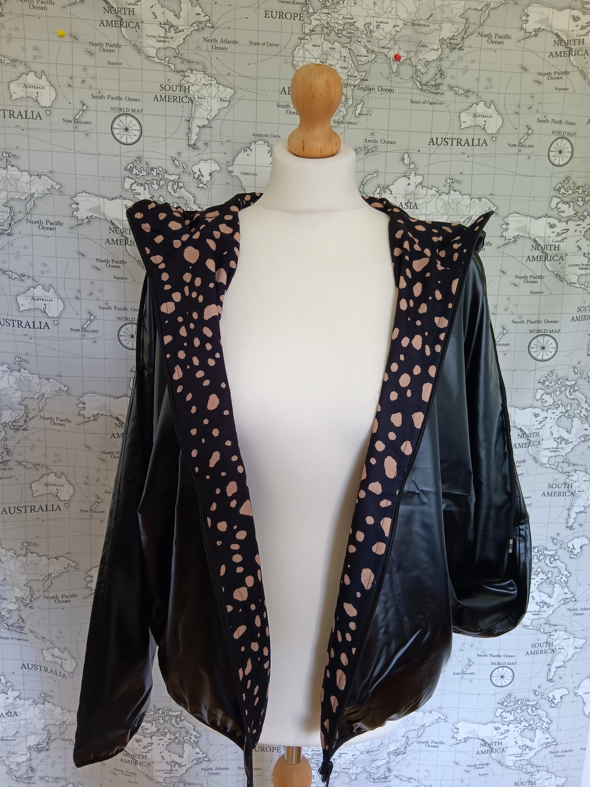 Reversible black rain jacket with polka dot lining on mannequin, Le Petit Placard fashion