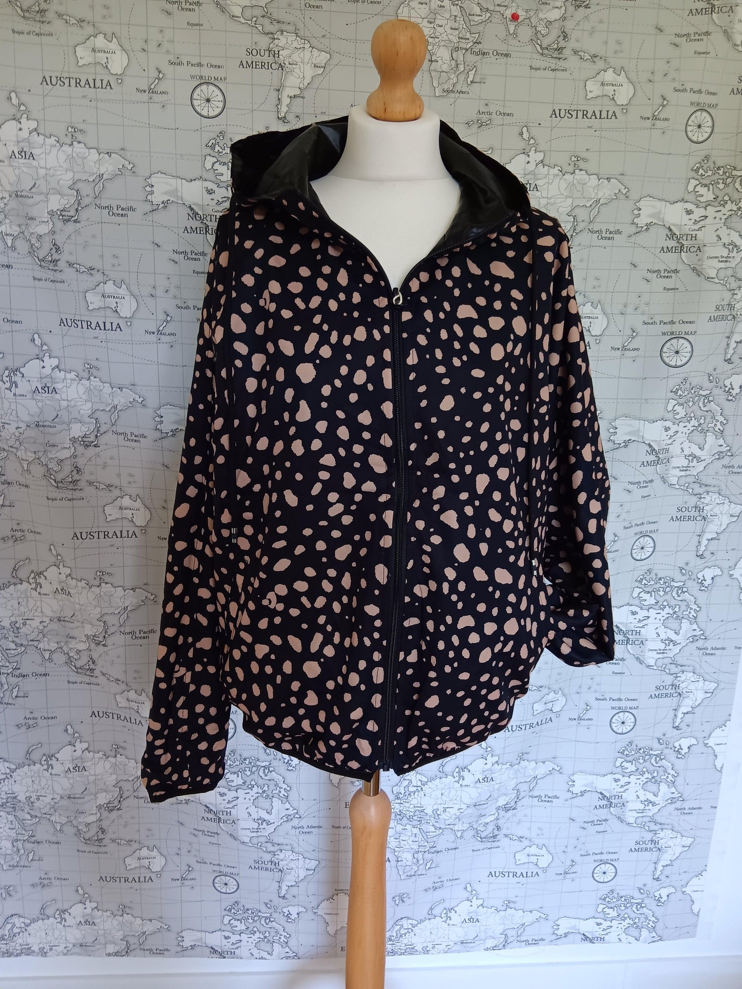 Black reversible rain jacket with beige spots on a mannequin, Le Petit Placard collection