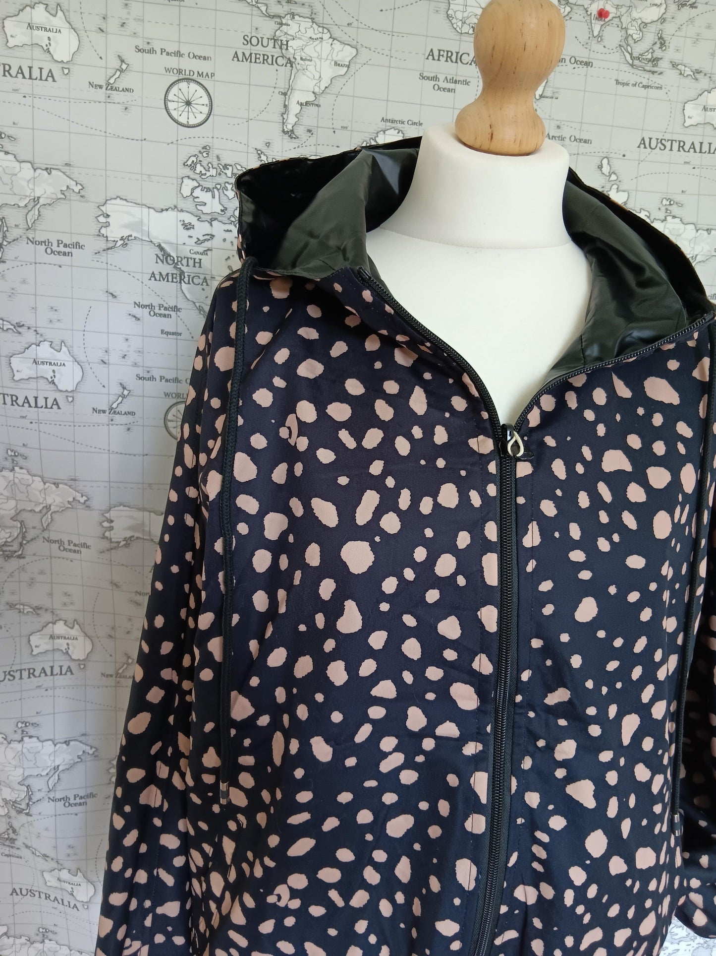 Reversible black raincoat with beige spots by Le Petit Placard, displayed on mannequin