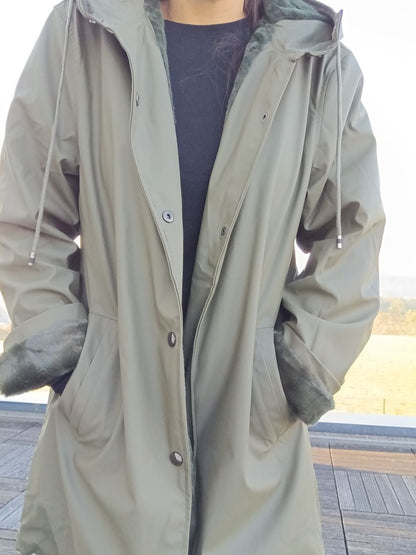 Woman wearing khaki Laura Jo raincoat with faux fur cuffs from Le Petit Placard outdoors