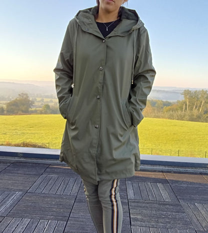 Woman wearing long khaki waterproof coat outdoors, Le Petit Placard fashion style