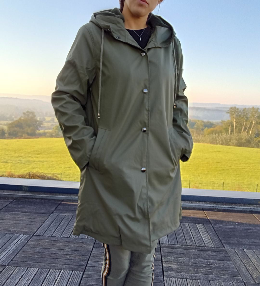 Woman wearing khaki long waterproof Laura Jo raincoat from Le Petit Placard outdoors