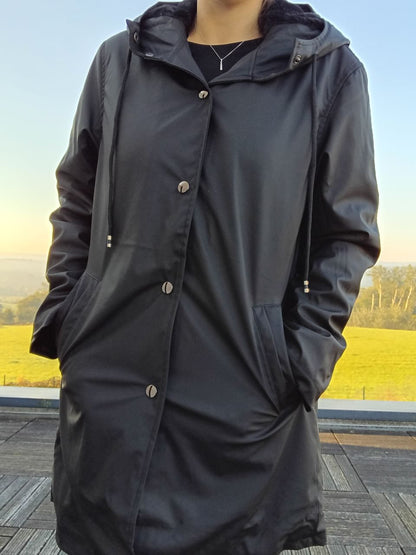 Laura Jo black raincoat with hood worn outdoors, Le Petit Placard fashion accessory